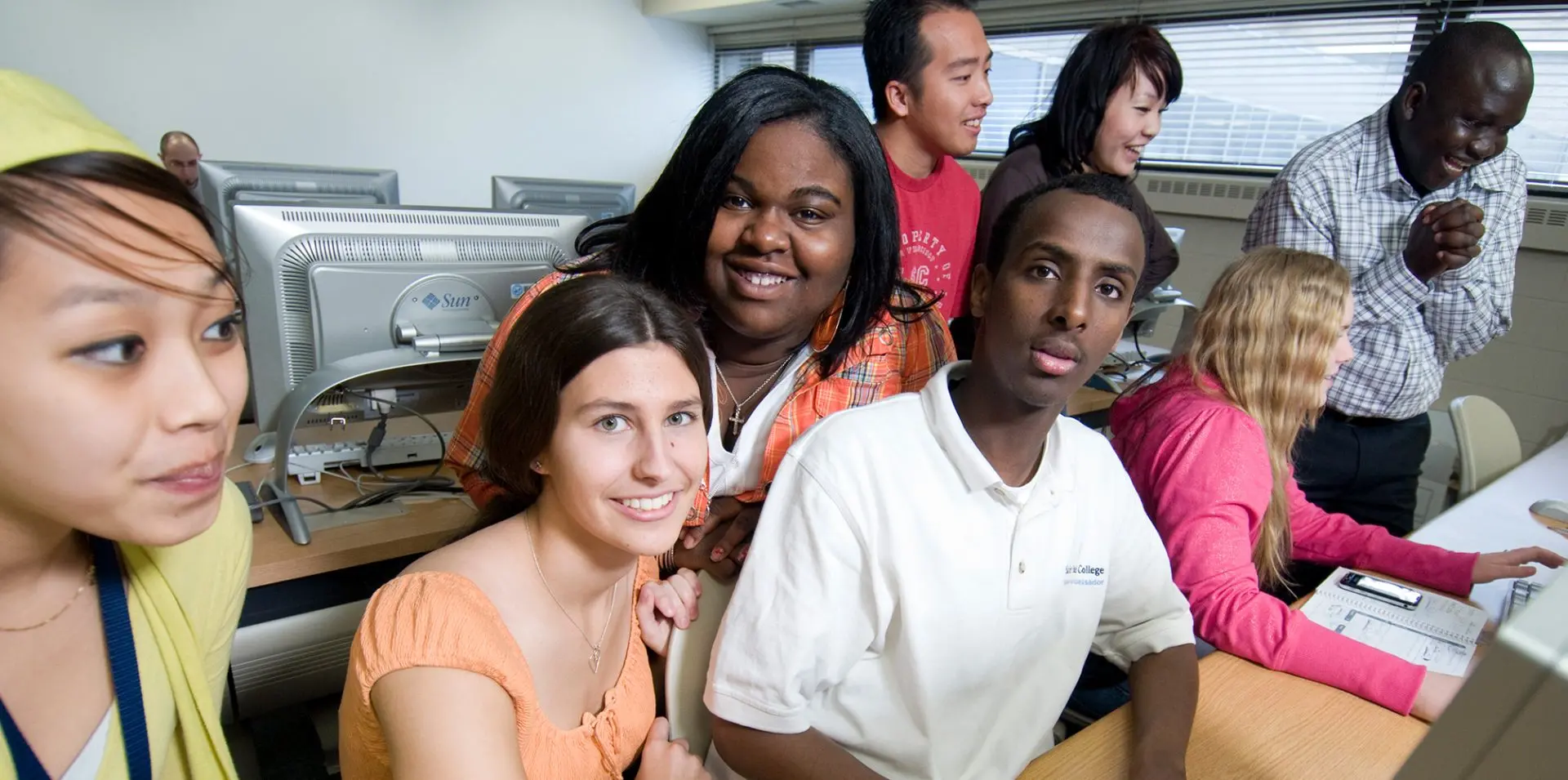 Photo of a group of students in a classroom using the computers.