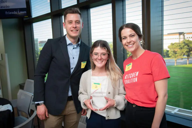 Three people accepting an award at Saint Paul College
