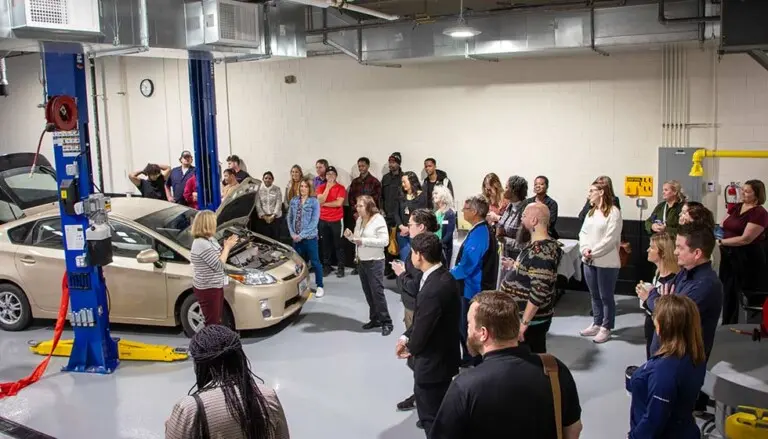 Dean Barber speaking to crowd in front of electric vehicles