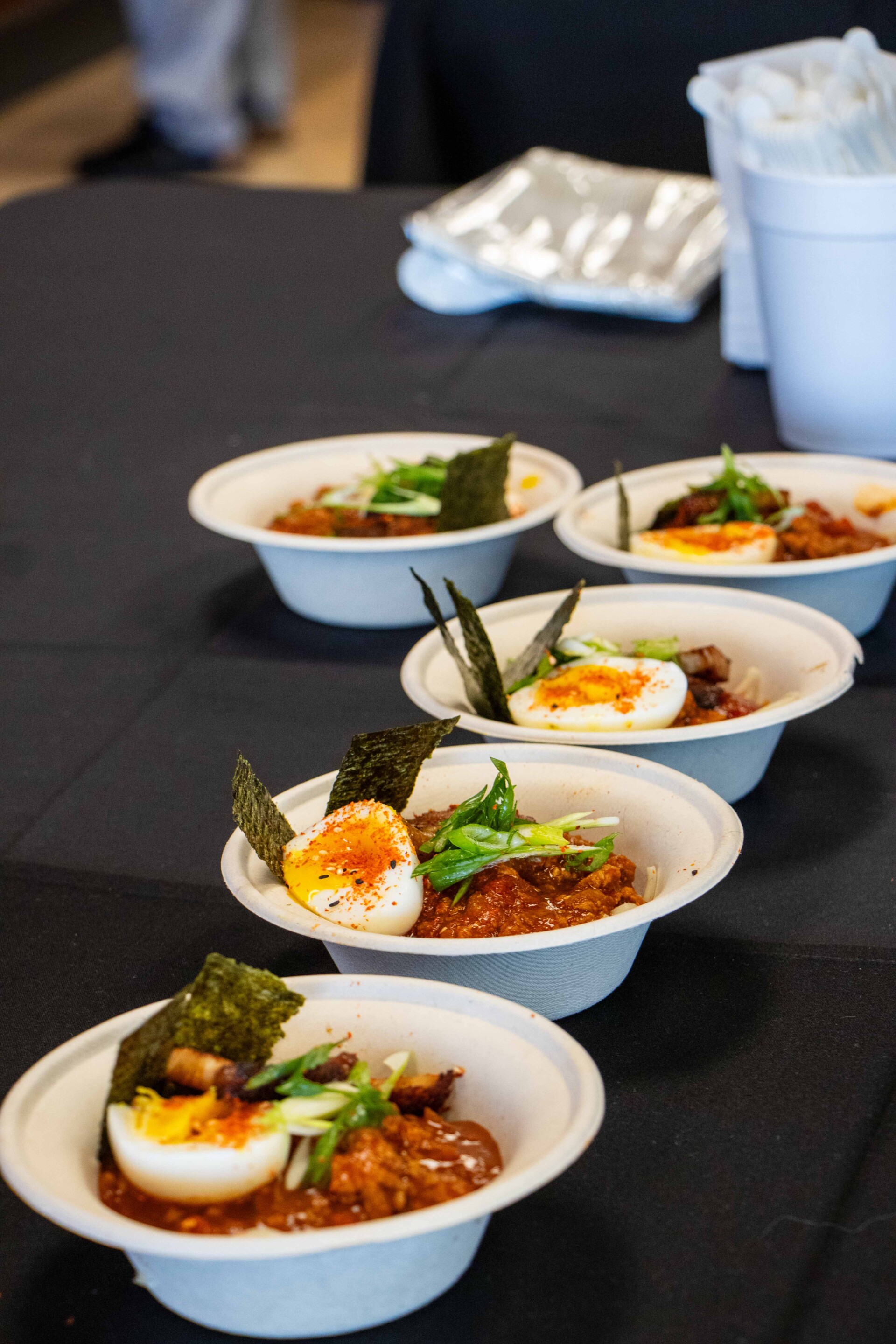 Five bowls of unique chili with an egg
