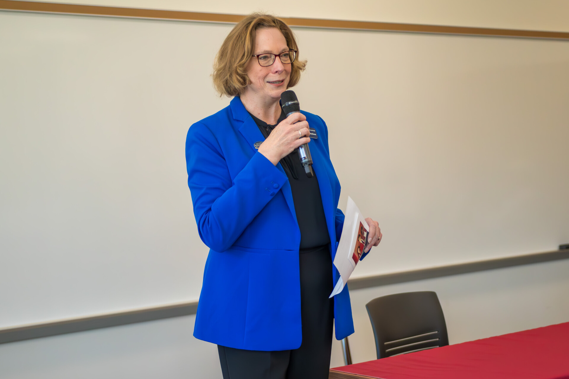 Dee Dee Peaslee speaking behind a table 