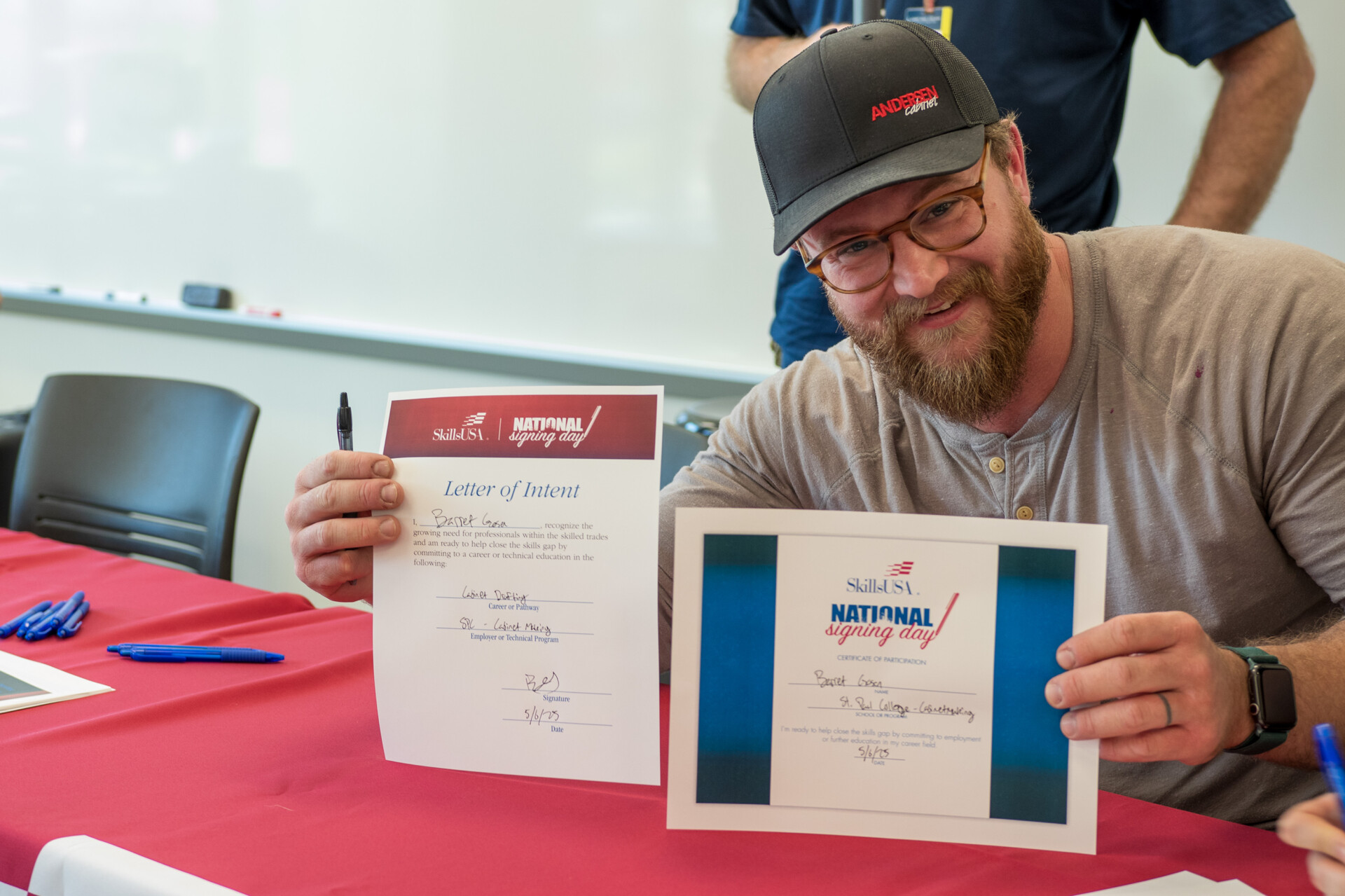 student holding two signed documents