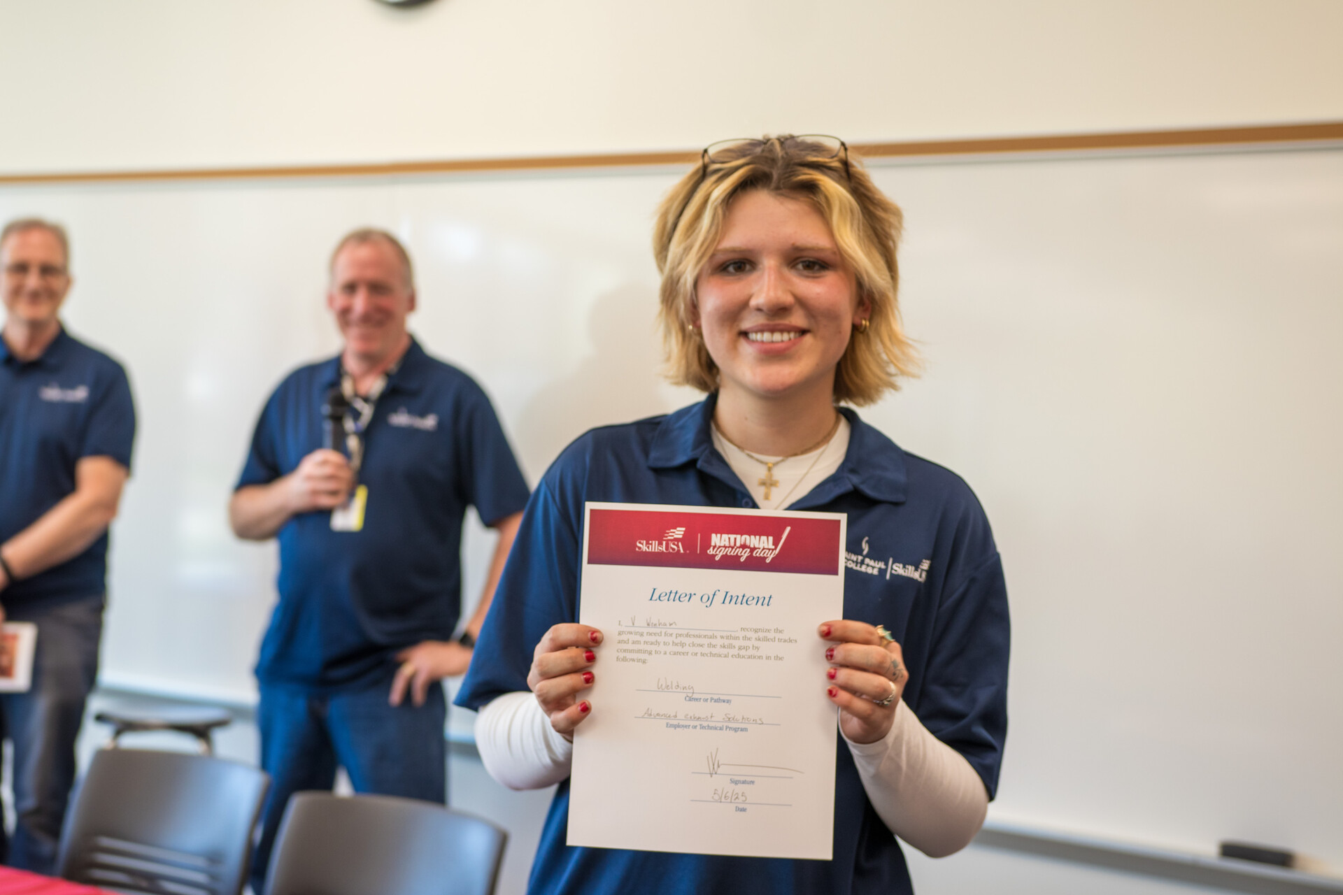 student holding a signed document