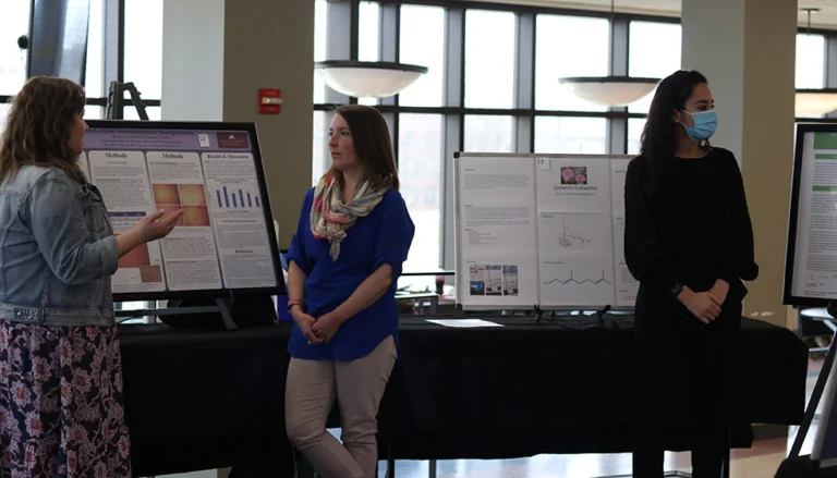 Courtney O’Kane speaking in front of a poster in 2022 at SPC