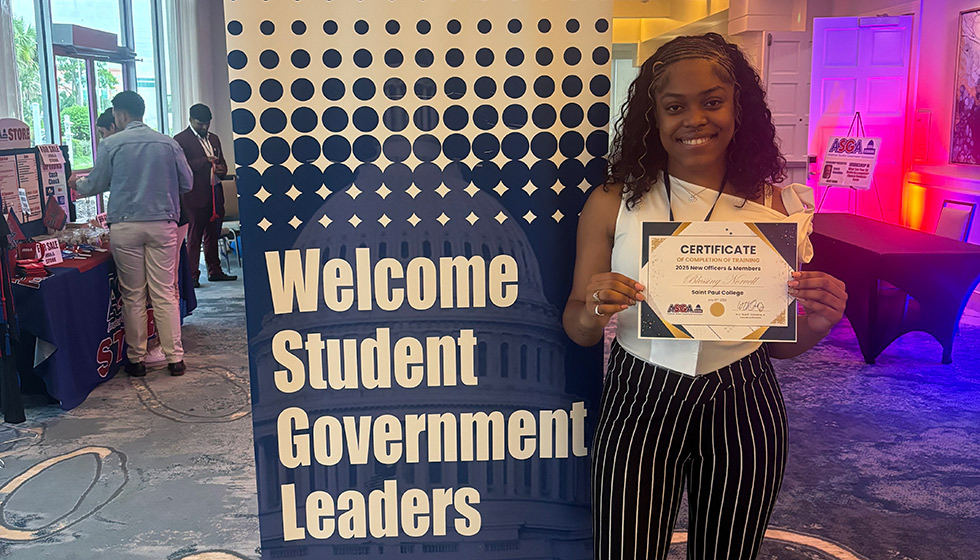 Blessing Norvell in front of a sign reading "welcome student government leaders"
