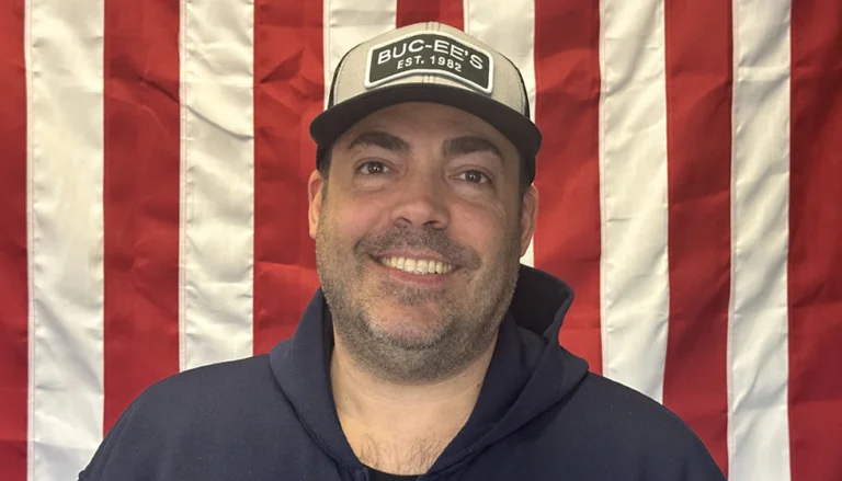 Greg Lawrence in front of an American Flag