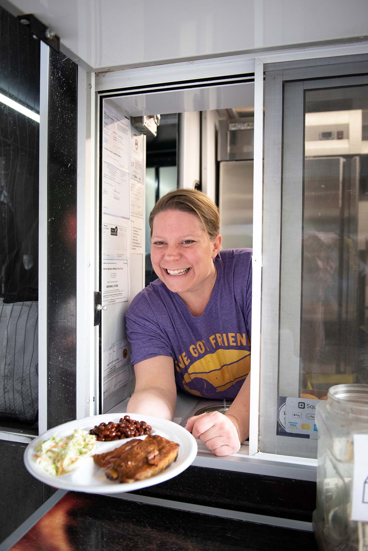 Food truck vendor serving meal to guest at Friends on the Lawn 2026 Saint Paul College event