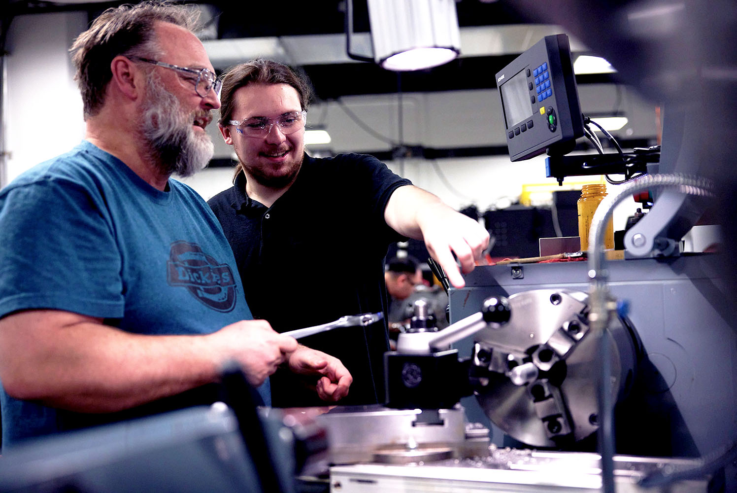 Two mean talking about a toolmaking machine
