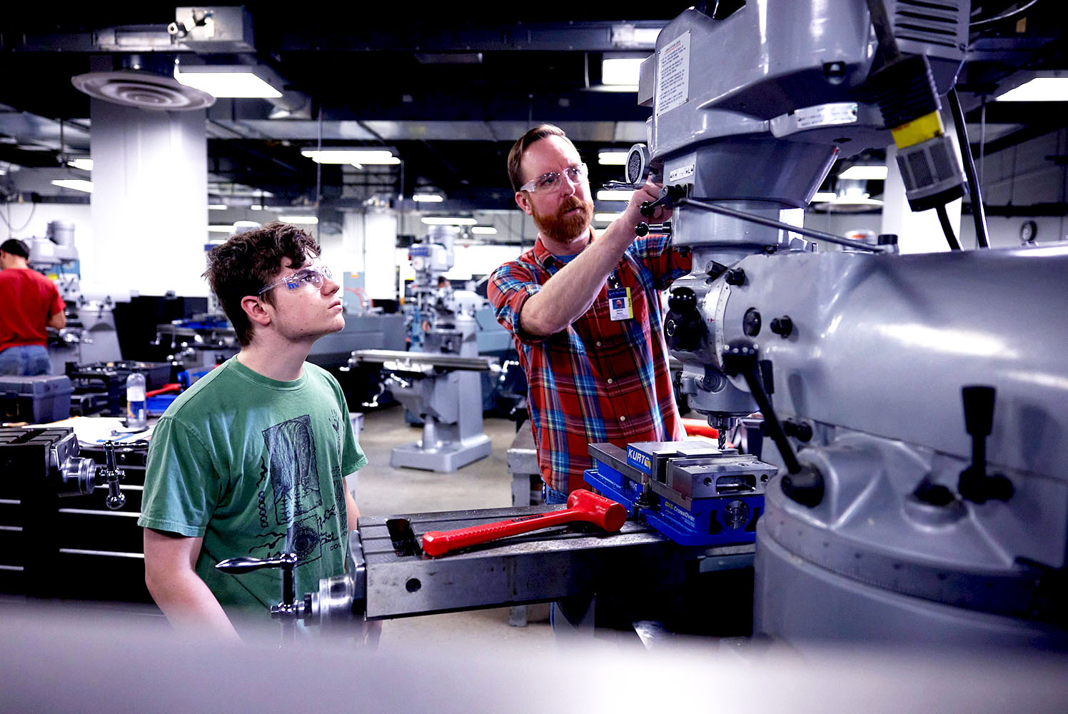 Instructor showing a student how to properly use a toolmaking drill