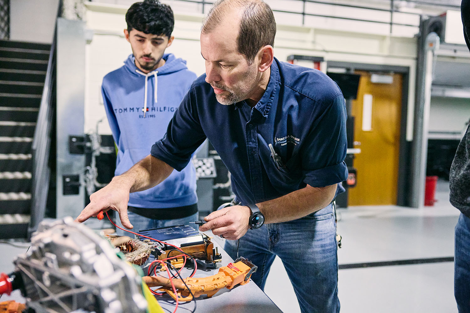 automotive students learning engine diagnostics in hands-on classroom workshop with instructor guidance