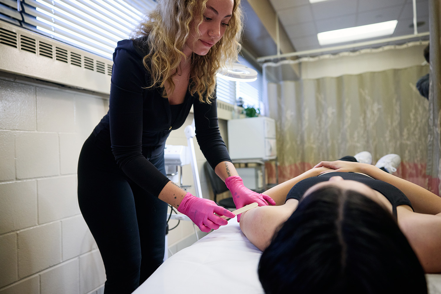 Esthetician working on the arms of a client.