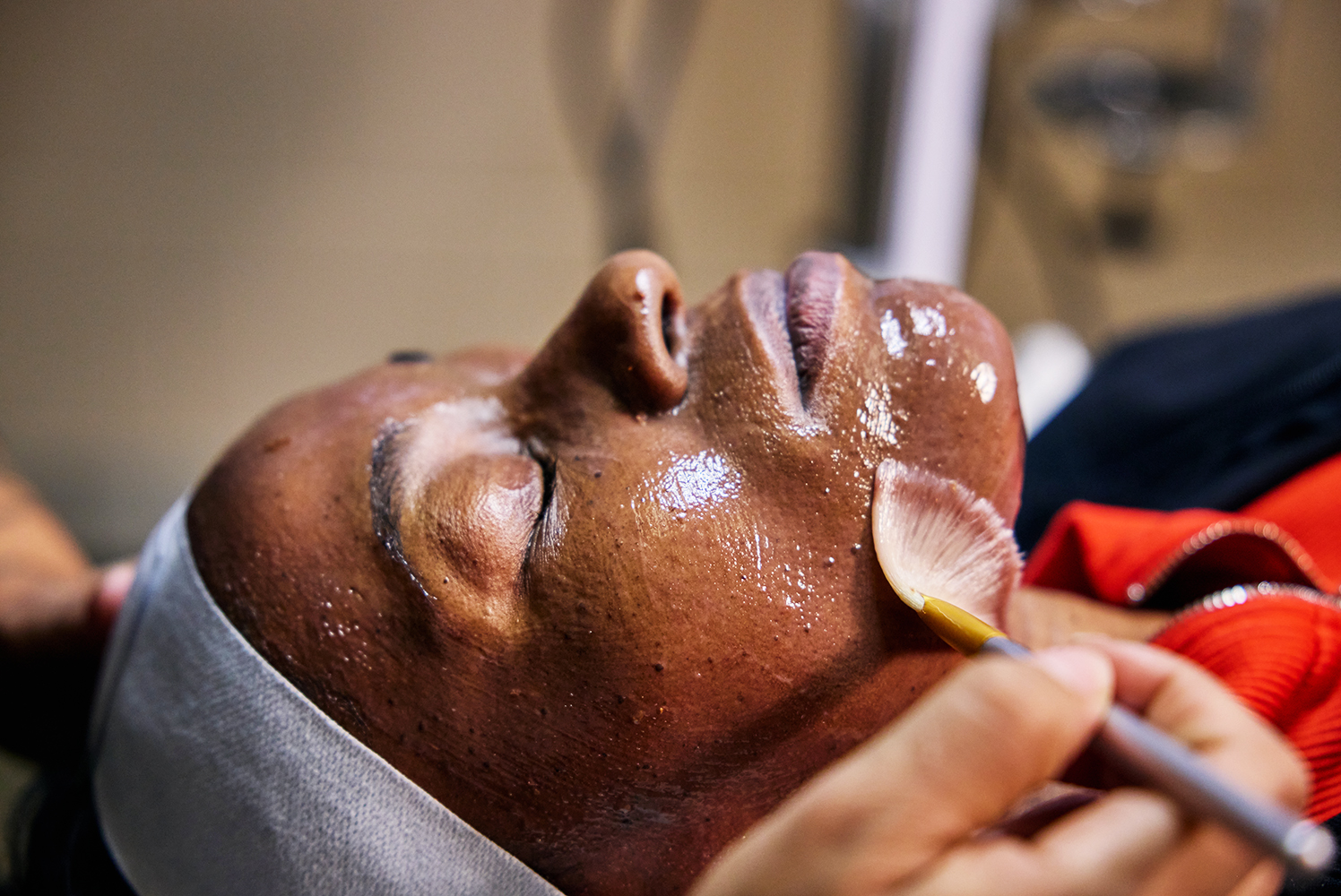 Closeup of a woman's profile as she is being brushed with an esthetics treatment.