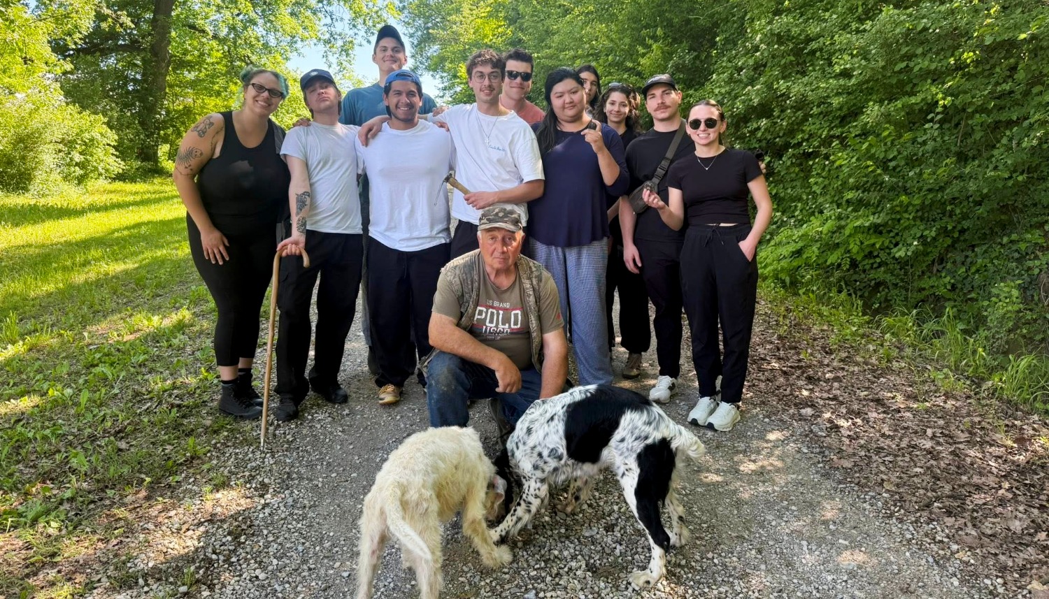 Culinary students study abroad Italy participating in truffle hunting experience with local guide and dogs during hands-on culinary training program