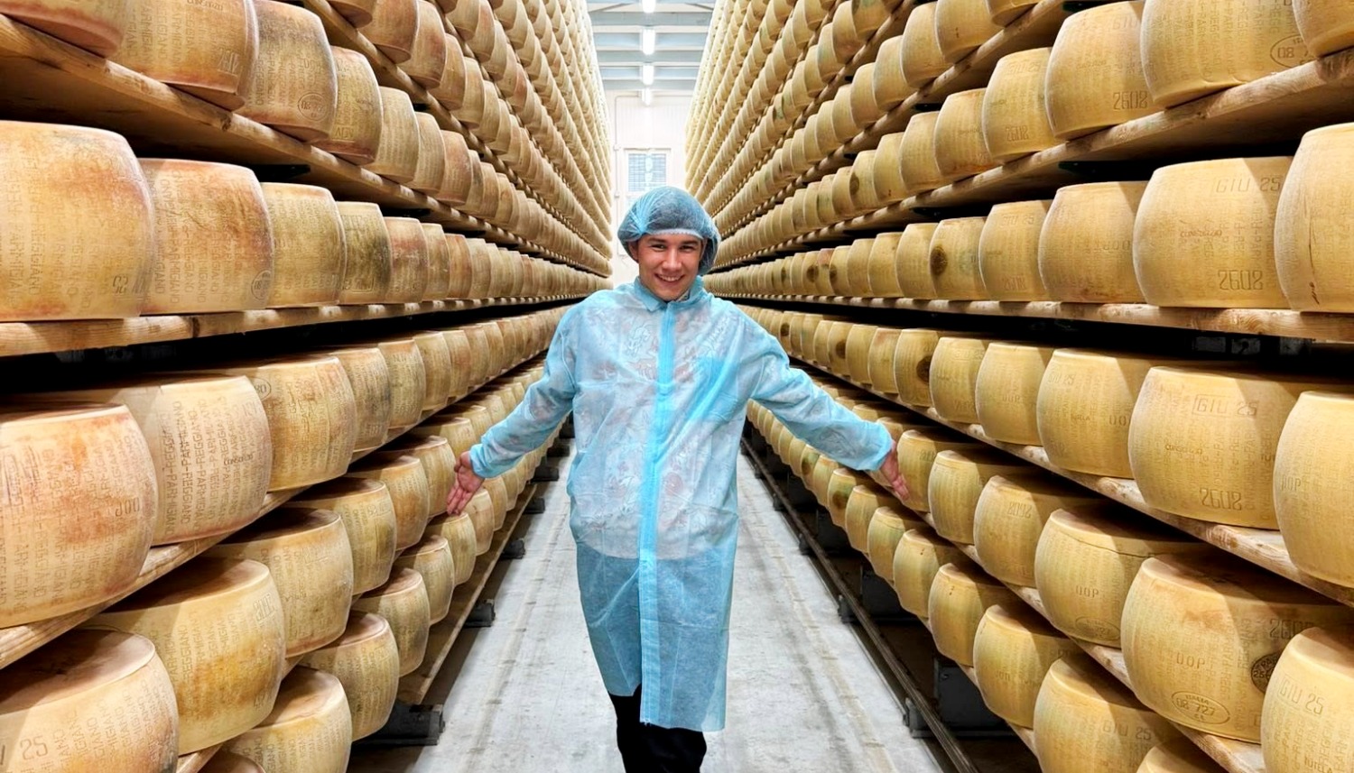 Culinary student in Parmigiano Reggiano cheese aging room during culinary study abroad Italy program learning traditional Italian food production