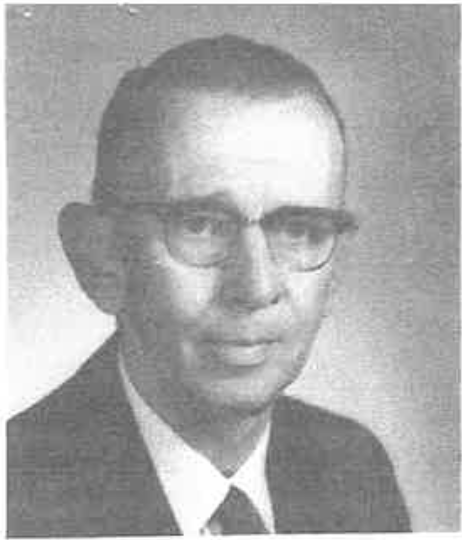 Black-and-white head-and-shoulders portrait of Harold Ostrem wearing eyeglasses, a dark suit jacket, white collared shirt, and dark tie. The person is facing slightly toward the camera against a plain, light-colored studio background. The image has a grainy texture typical of an older printed photograph.