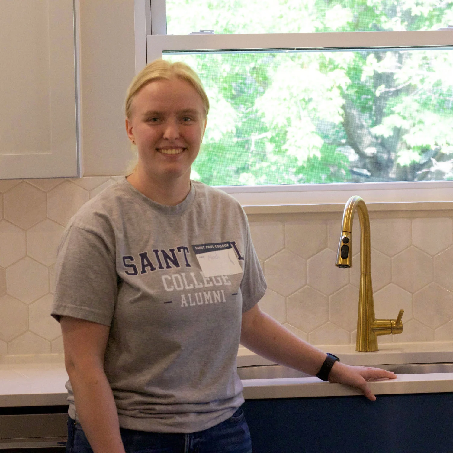 SPC student standing in front of the work she did in the kitchen of the duplex