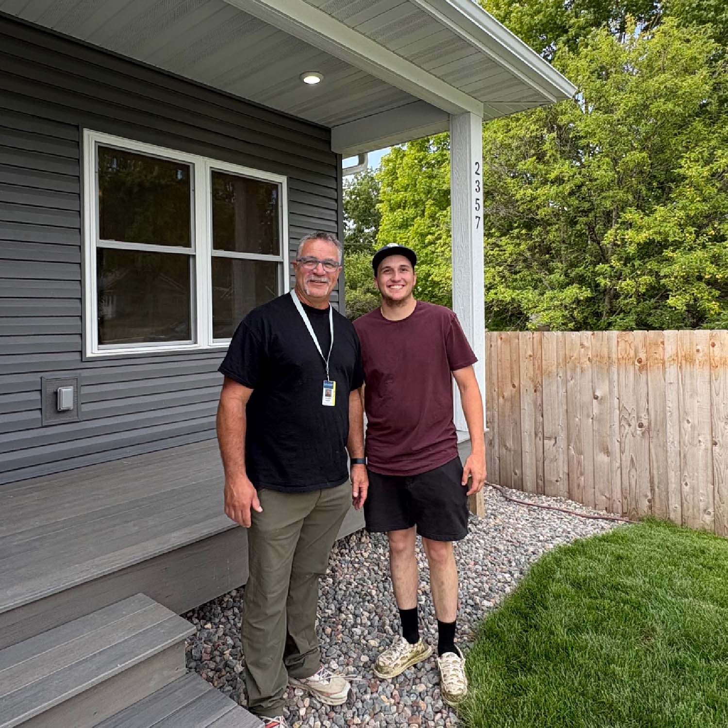 Thomas Leiskau standing in front of a porch with a student