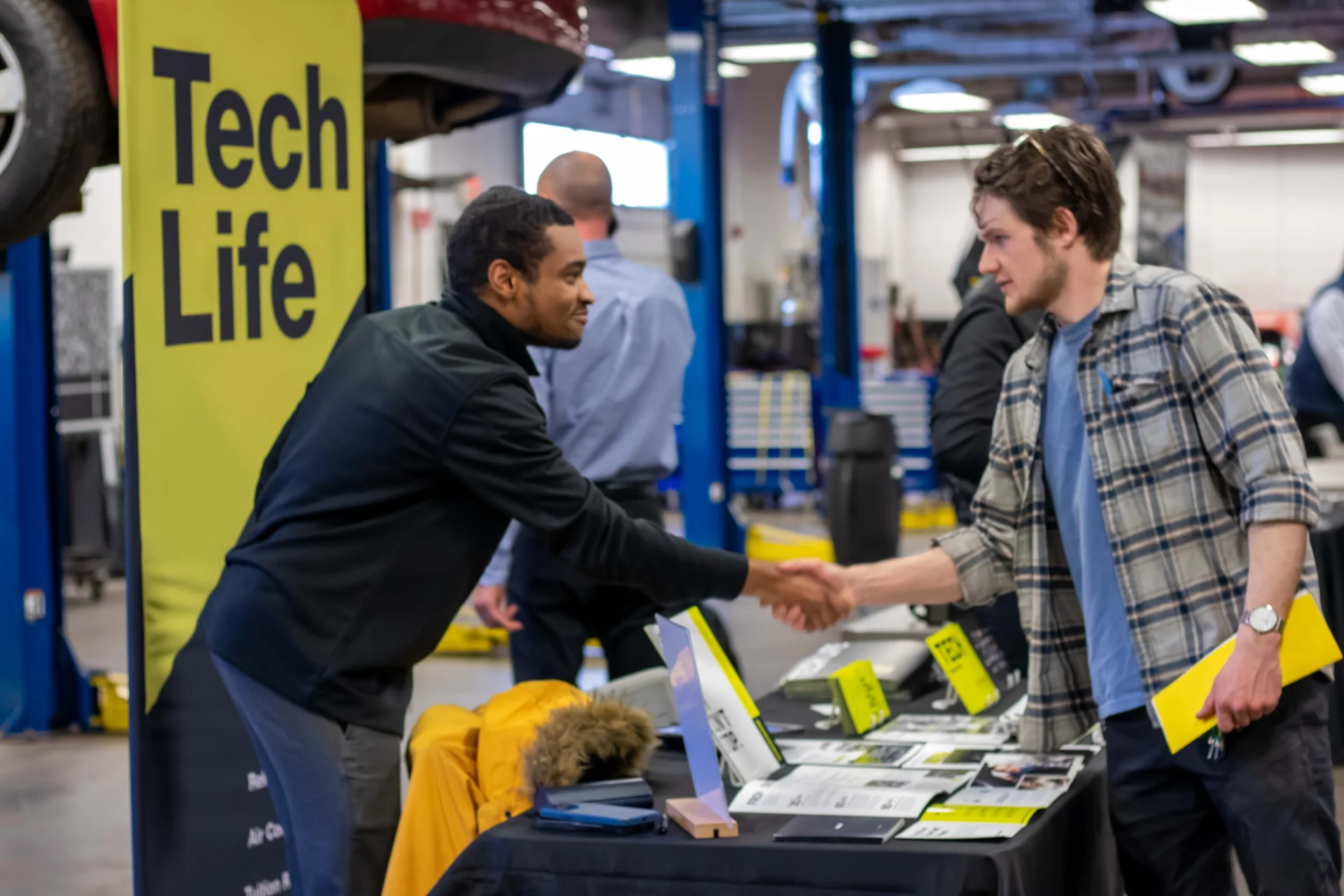 Photograph of an employer shaking hands with a student at a career fair