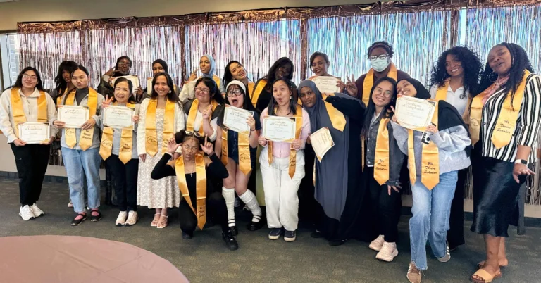 2025-2026 We Thrive graduates wearing their sashes and holding up their certificates at the graduation reception for We Thrive