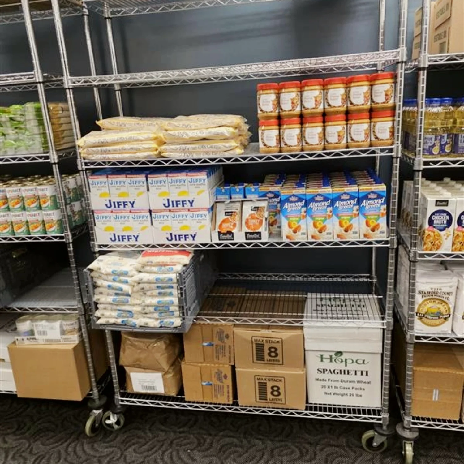 Metal shelf in the Campus Food Pantry with nonperishable grocery items for shoppers to choose from.