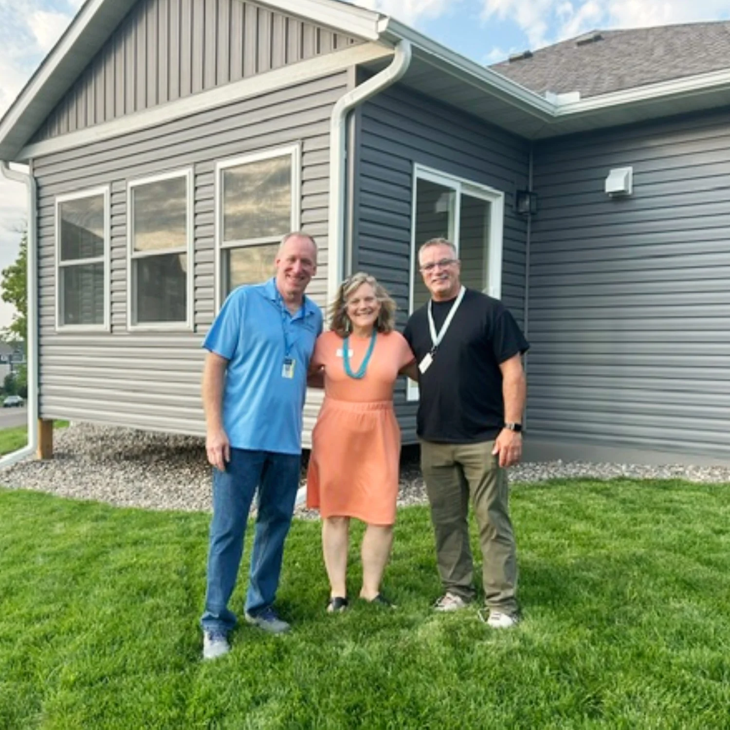 V.A. Barber, Thomas Hillstead, and Thomas Leiskau standing in the yard in front of the duplex