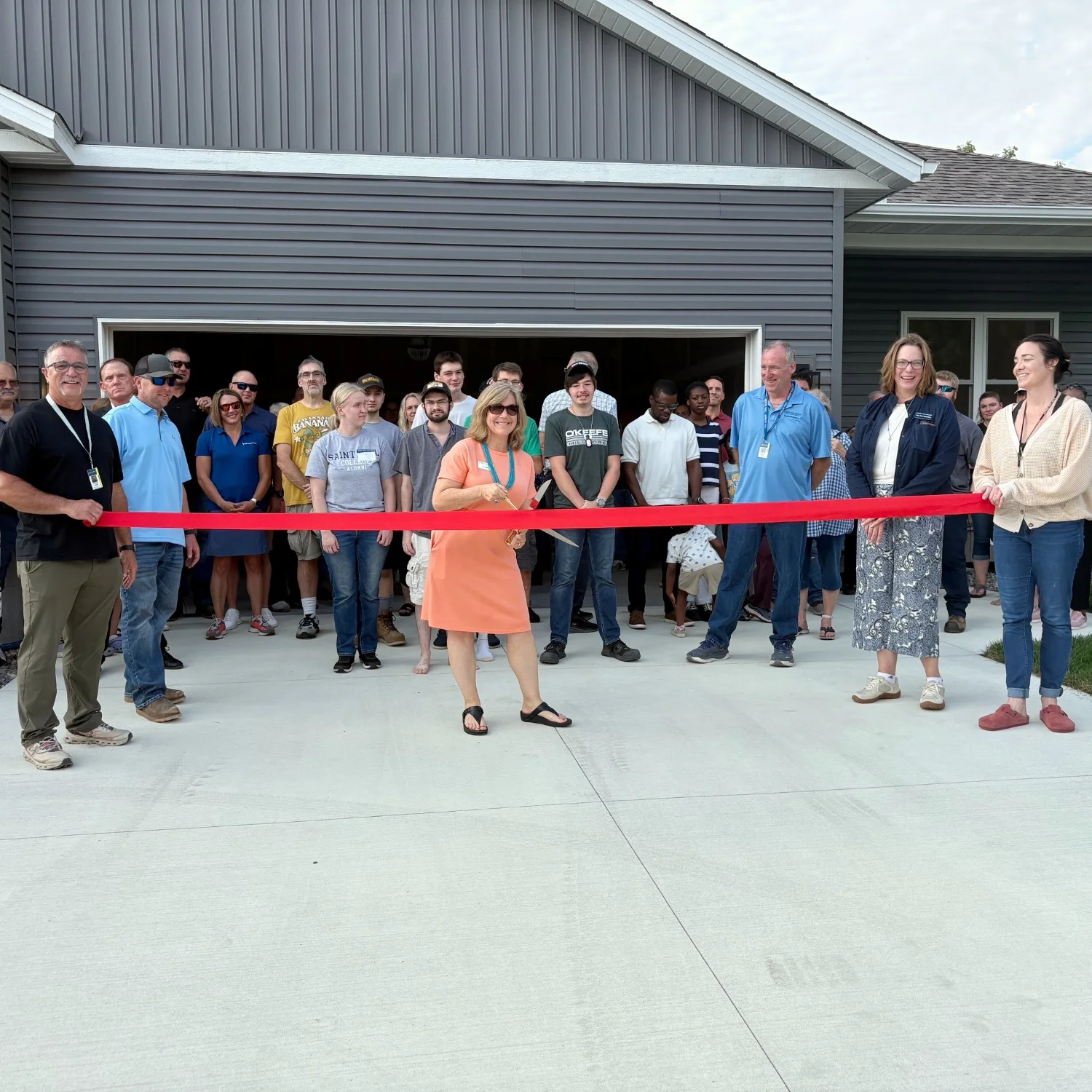 V.A. Barber, President Peaslee, and other staff, faculty, and students behind the ribbon during the cutting ceremony