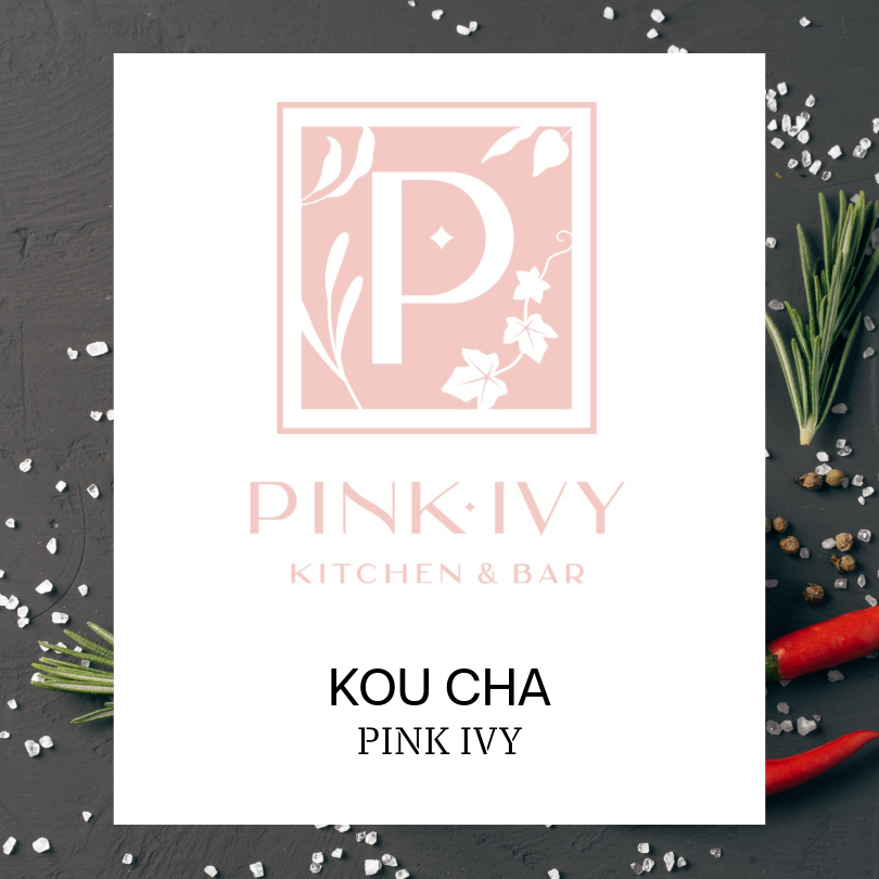 Pink Ivy Kitchen & Bar logo displayed on a white card centered over a dark textured background with scattered coarse salt, rosemary sprigs, peppercorns, and red chili peppers. The logo features a pale pink decorative letter "P" inside a floral border. Below the logo, the text reads "KOU CHA" and "PINK IVY."