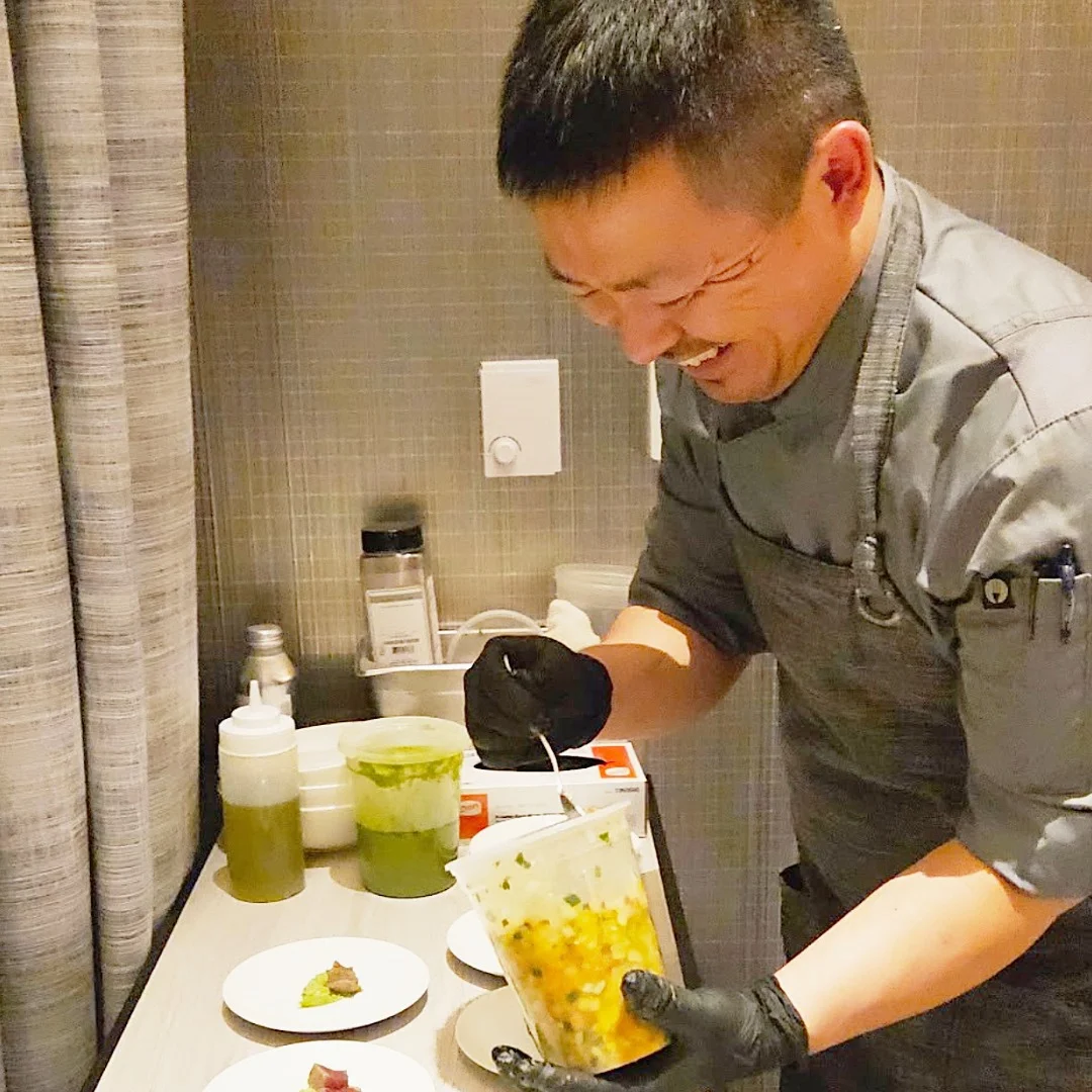 Kou Cha smiling while plating small dishes